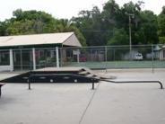 Concrete skatepark with bars and ramps dotted around the park