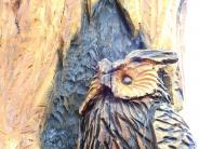 A close up of a chainsaw carving of an owl sitting on a tree