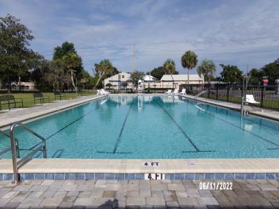 Pool filled with clear blue water with painted lanes surrounded with benches and reclining chairs